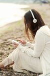 teen-girl-sitting-sea-sand-listening-music-by-earphones_251840-1866~2.jpg