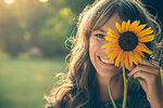 girl-in-park-covering-face-with-sunflower.jpg