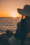 woman-in-a-hat-looking-at-sunset-above-the-sea-free-photo.jpg